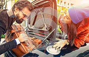 Beautiful fashion couple going to vacations, loading their car boot with leather travel suitcases  - Travel fashion and hipster