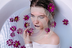Beautiful fashion model girl taking milk bath