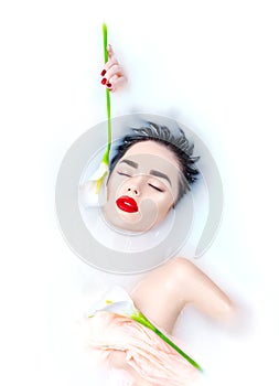 Beautiful fashion model girl taking milk bath, spa and skincare