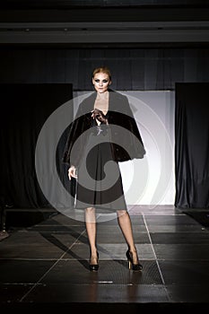 Beautiful fashion model  on runway in fur coat and evening dress