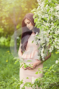 Beautiful fashion model woman in blossom spring flowers garden