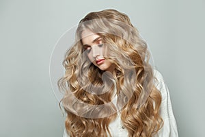 Beautiful fashion woman hair model with long blonde healthy curly hairstyle on white background