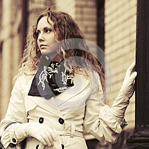 Beautiful fashion woman in trench coat walking on city street