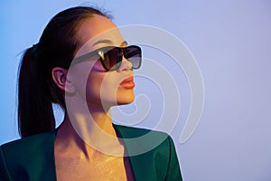Beautiful fashion woman in sunglasses. Blue background