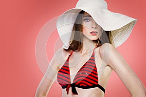 Beautiful fashion woman in white hat and red swimsuit