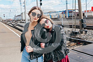 Beautiful fashion women posing. Trendy lifestyle urban portrait on city background.stylish girlfriend in sunglasses at the railway