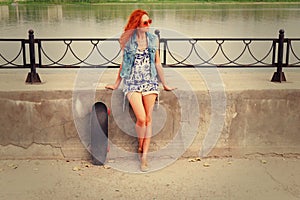 Beautiful and fashion young woman posing with a skateboard