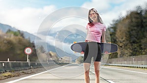 Beautiful and fashion young woman posing with a skateboard. Sport emotion. Cheerful girl with tattoos posing with a