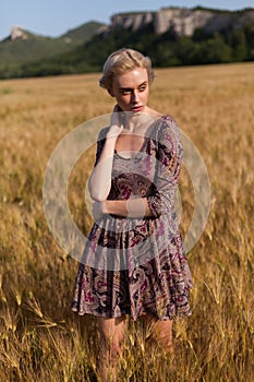 Beautiful fashionable blonde woman in a field of rye