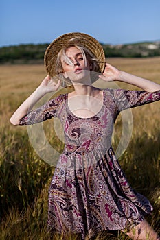 Beautiful fashionable blonde woman in a field of yellow ripe wheat