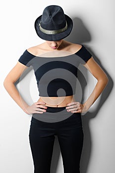 Beautiful fashionable girl in black clothes and black hat