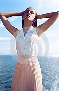 Beautiful fashionable girl posing on sea