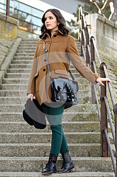 Beautiful fashionable girl standing on the stairs