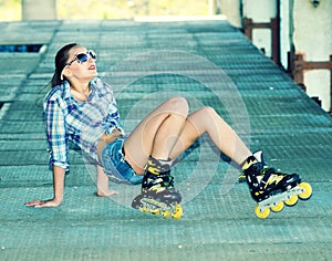 Beautiful fashionable girl in white sunglasses on roller skates.