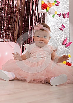 Beautiful fashionable little baby in pink dress. little princess poses like a doll