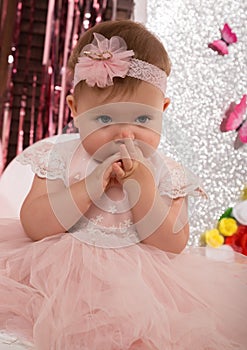 Beautiful fashionable little baby in pink dress. little princess poses like a doll