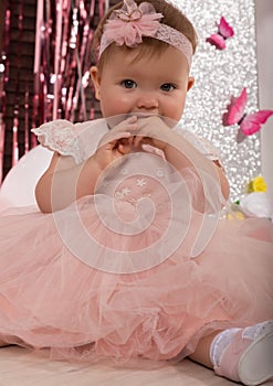 Beautiful fashionable little baby in pink dress. little princess poses like a doll