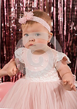 Beautiful fashionable little baby in pink dress. little princess poses like a doll