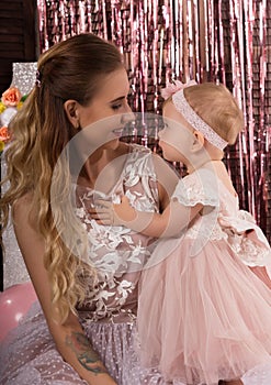 Beautiful fashionable little baby in pink dress. little princess poses like a doll with her mam