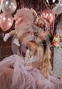 Beautiful fashionable little baby in pink dress. little princess poses like a doll with her mam