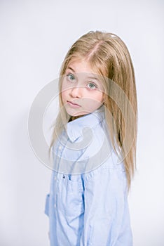 Beautiful fashionable little girl with blond hair in jeans clothes on a white background