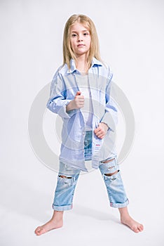 Beautiful fashionable little girl with blond hair in jeans clothes on a white background