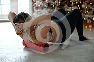 A beautiful fat woman in a sports uniform is exercising in the body to burn fat. Fitness and yoga. Sports at Christmas.