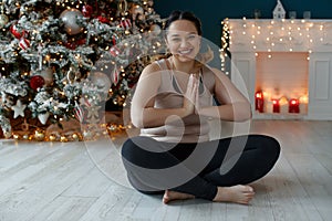 A beautiful fat woman in a sports uniform is exercising in the body to burn fat. Fitness and yoga. Sports at Christmas.