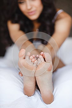 Beautiful feet, lying in the bed of a young woman