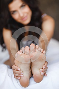 Beautiful feet, lying in the bed of a young woman