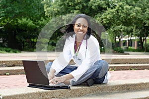 Beautiful female African American college student on campus wearing whitecoat