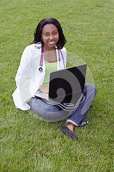 Beautiful female African American college student on campus wearing whitecoat