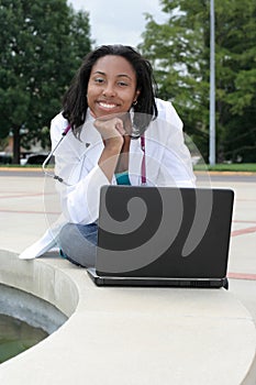 Beautiful female African American college student on campus wearing whitecoat