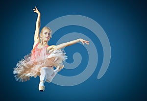 Beautiful female ballet dancer on a grey background. Ballerina is wearing pink tutu and pointe shoes.