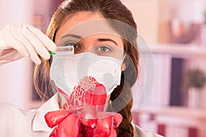 Beautiful female biologist experimenting with red