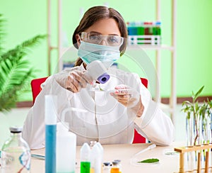 Beautiful female biotechnology scientist chemist working in lab