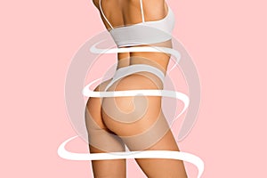 Beautiful female body in underwear over pink background. Beauty fitness concept