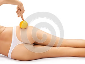 Beautiful female booty with an orange isolated on a white background.