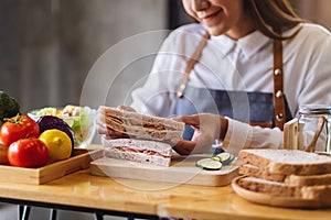 A beautiful female chef cooking a whole wheat ham cheese sandwich in kitchen