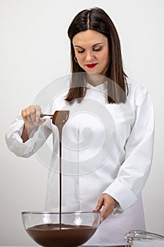 Female chef making premium hand-crafted chocolate, stirring melted chocolate