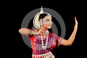 Beautiful Female Classical Odissi dancer performing Odissi Dance on stage in special attire at Konark Temple, Odisha, India.