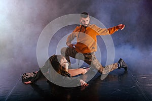 The beautiful female dancer is laying on the floor while her male partner performs an exotics unique modern art moves over her