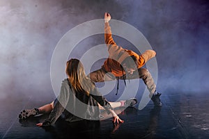 The beautiful female dancer is laying on the floor while her male partner performs an exotics unique modern art moves over her