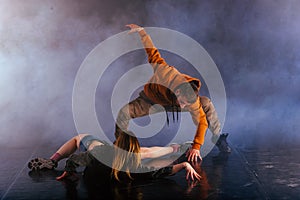 The beautiful female dancer is laying on the floor while her male partner performs an exotics unique modern art moves over her