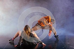 The beautiful female dancer is laying on the floor while her male partner performs an exotics unique modern art moves over her