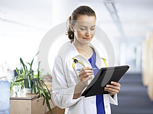 Beautiful female doctor examining the patient chart