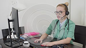 Beautiful female doctor having online conversation with a patient. Sitting in front of computer