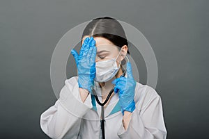 Beautiful female doctor holding stethoscope and smiling isolated on grey background