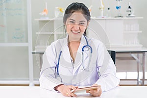 Beautiful female doctor at medical office wearing stethoscope and lab coat in hospital