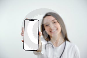 Beautiful female doctor showing a smart phone screen isolated isolated on a white background